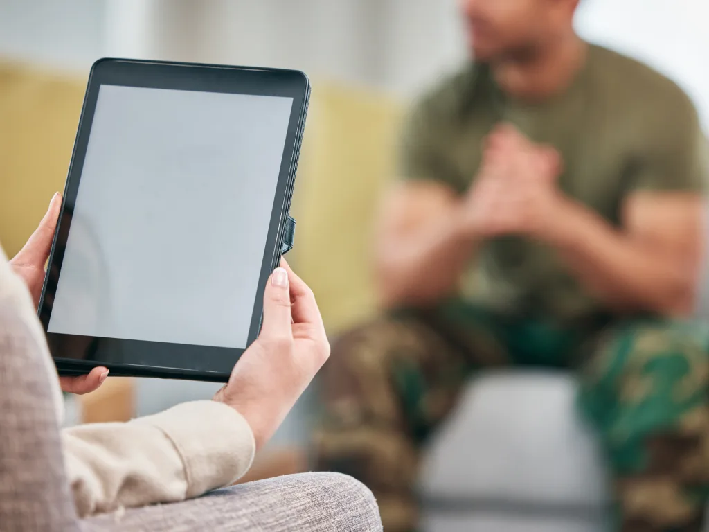 Image of a member of the army in camouflage uniform speaking to a therapist