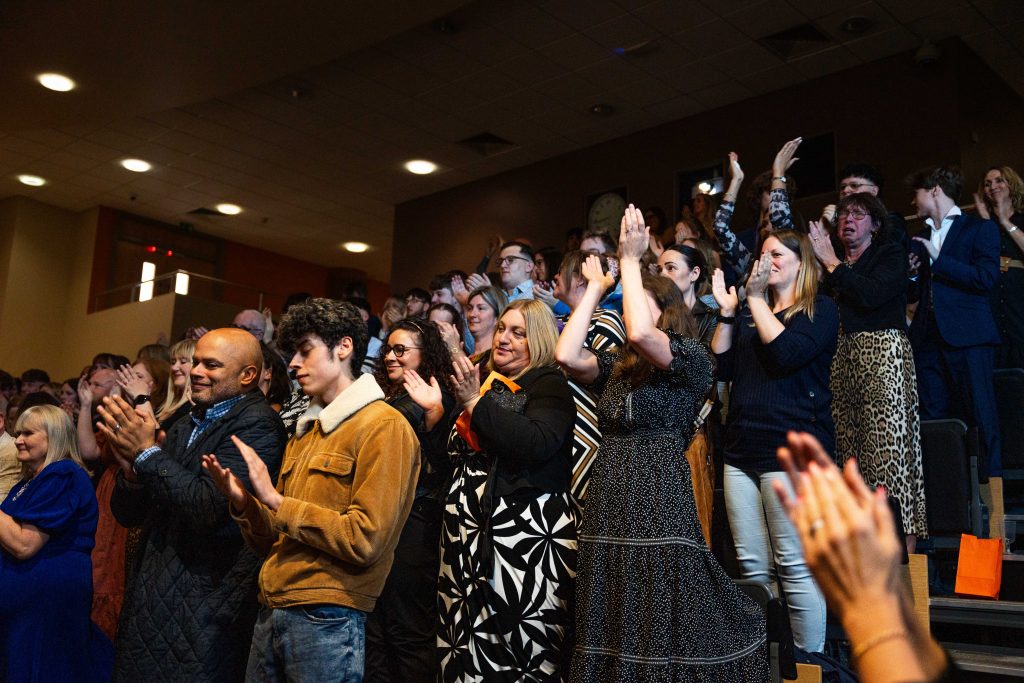The audience of the premier clapping and standing.