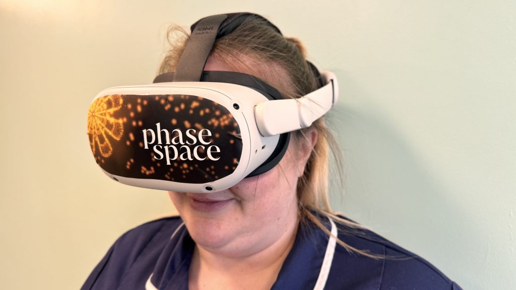 Staff member wearing VR headset with the words 'phase space' on the headset.