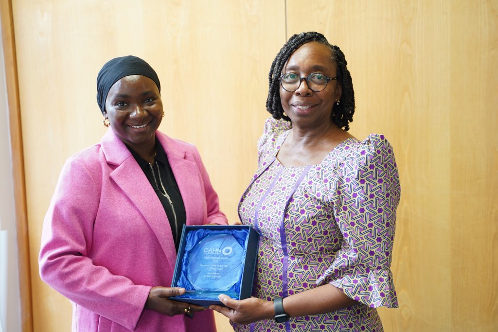 Taiwo Atanda presenting a glass trophy to Buki Adeyemo following Buki being awarded Executive Leader of the Year at the Black Healthcare Awards 2025.